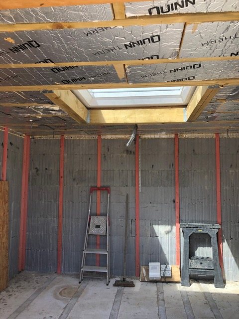Interior wall with first-fix electrical conduit run vertically before lining