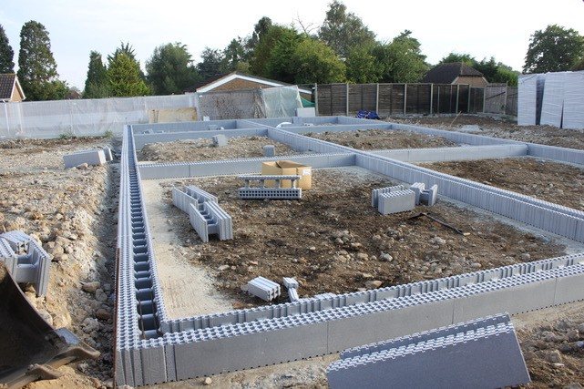 Insulated formwork blocks laid out as a level perimeter across a cleared plot